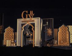 the entrance to g v international is lit up at night with gold and black decorations