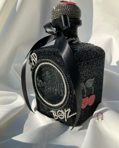 the bottle is decorated with black fabric and has a bow around it's neck