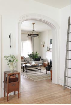 a living room filled with furniture and a ladder