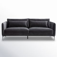 a black couch sitting on top of a white floor