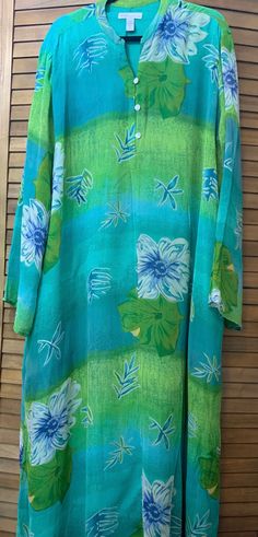 This Studio by Valerie Stevens garment is a beautiful shades of green summer dress/Kaftan in size 3X  This beautiful fully lined Kaftan/long dress in shades of green is perfect to be a beach/pool coverup or a dress for a casual summer event.  Features include a wispy shell with stylized flowers on a variegated green background.  The garment is lined except for the sleeves, has front buttons to below the chest, long sleeves, mandarin collar, and dual side vents in both the shell and the lining. Green Summer Dress, Hawaiian Clothing, Green Summer Dresses, Dress Kaftan, Hawaiian Outfit, Summer Events, Green Background, Beach Pool, Mandarin Collar