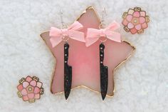 These cute earrings have little black knives! They are made with sparkly black resin. The knife charms dangle from pink bows with holographic edges on silver colored earring hooks. The knife charms are 2 1/2 inches long. ʕ*́ᴥ*̀ʔっ♡ I typically ship within two days. If there are any issues with your order, please contact me as quickly as possible. To request a custom order, please click on the "Request Custom Order" button on my shop's home page. Please do not request customization after purchase or in order notes. Black Knives, Knife Earrings, Yami Kawaii, Pink Bows, Black Resin, Earring Hooks, Fun Earrings, Cute Earrings, Pink Bow