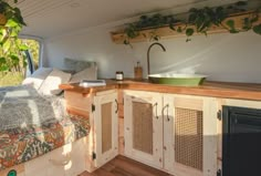 a kitchen area in a tiny home with wood flooring and white walls, built into the ceiling