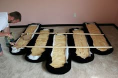 a man is working on some kind of bed made out of sheepskins and plywood