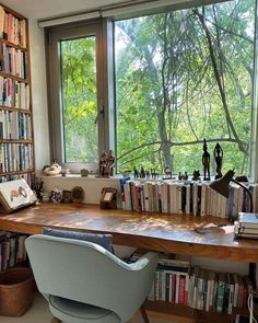 a chair sitting in front of a window filled with lots of books next to a book shelf