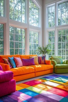 a living room filled with lots of colorful furniture next to large windows and a rainbow rug on the floor