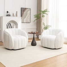 two white chairs sitting on top of a wooden floor next to a round table in front of a window