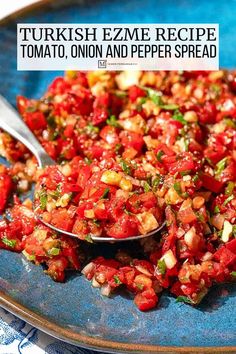 a blue plate topped with lots of food and a spoon filled with tomato rezeme