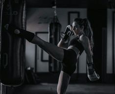 a woman is kicking a kick with her leg in the air while wearing boxing gloves