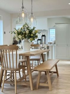 a dining room table with chairs and a vase filled with flowers