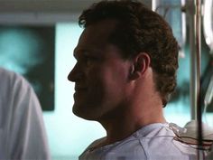 a man in white shirt standing next to another man with his head tilted back and looking off into the distance