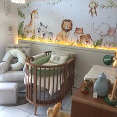 a baby's room with a crib, rocking chair and wall mural