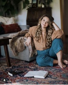 a woman sitting on the floor in front of a couch