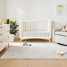 a baby's room with a white crib and toys on the floor in front of it