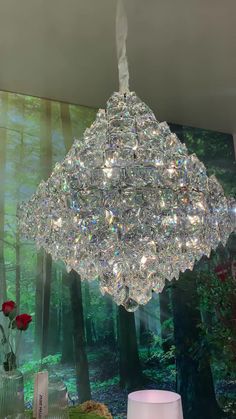 a crystal chandelier hanging from the ceiling in a room with flowers and vases