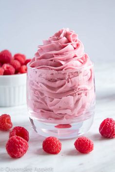 raspberry mousse in a glass bowl with fresh raspberries around it