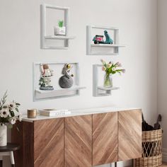 a white wall with three wooden shelves and vases on the sideboard next to it