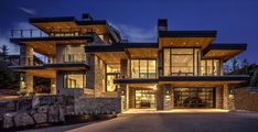 a large house with lots of windows and lights on it's front entrance at night