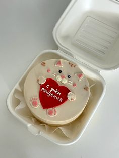 there is a cake in the shape of a cat with a red heart on it