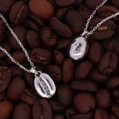 This coffee bean necklace is the result of a collaboration with our friends at Kona Coffee Purveyors in Honolulu. Our intention was to make an elevated coffee bean jewelry collection for their discerning customers, and we think we hit the mark! The pieces are solid sterling silver with oxidized details, and each one has a row of channel-set white topaz in the center. The back of the pendant has KCP's logo, the ‘Ākepa bird, which lives in the Ohia Lehua forest on the Big Island where Kona Coffee is grown. We started the project during Covid so it took an extra long time to roll out, but these pieces are finally finished and available in their beautiful cafe in Waikiki and on both of our websites. We hope everyone enjoys these pieces as much as we enjoyed designing them! Diamond cut chain is Ohia Lehua, Bean Jewelry, Golden Coffee, Bean Necklace, Beautiful Cafe, Kona Coffee, Tv Gift, The Big Island, Channel Set