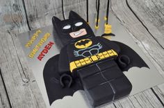 a birthday cake made to look like a lego batman with the bat symbol on it