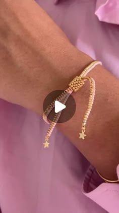 a woman's arm with a gold bracelet and an arrow charm on the wrist