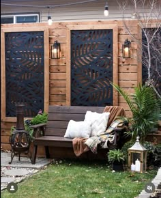 a wooden bench sitting on top of a grass covered field next to a fence and potted plants