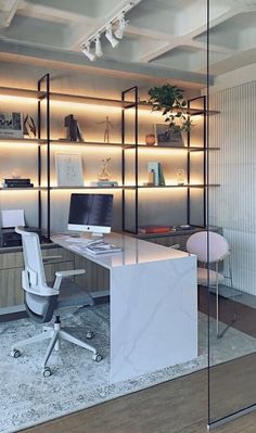 an office with glass walls and white desks in front of the wall is illuminated by recessed lighting