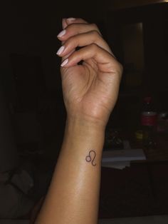 a woman's arm with a small heart tattoo on the left side of her wrist