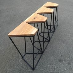 three wooden tables sitting on top of each other in the middle of a parking lot