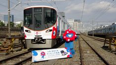 the train is stopped on the railroad tracks with its conductor and mascot next to it