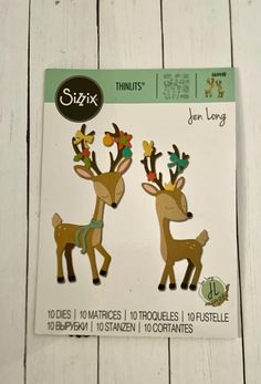 two deer dies are shown on a white wooden surface with the words sizzix