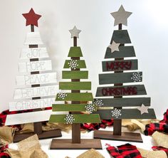 three wooden christmas trees are on display