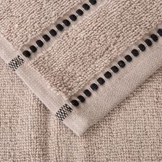 a close up view of a beige blanket with black and white stitchs on it