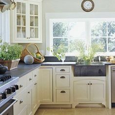 a kitchen filled with lots of white cabinets and counter top space next to a window