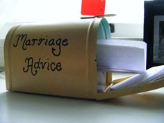 a mailbox with the words marriage advice written on it and a photo frame behind it