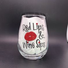 a wine glass with red lips and wine sips on it