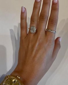 a woman's hand with two gold rings and a diamond ring on her finger