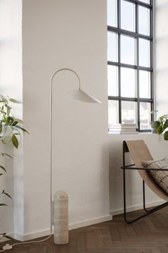 a floor lamp next to a chair and window