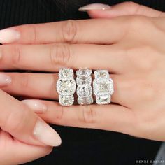 a woman's hand with three diamond rings on her left and the other hand holding an engagement ring