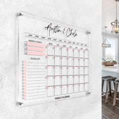 a calendar hanging on the wall next to stools and a kitchen table with chairs