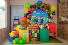 a birthday party with balloons and decorations in the shape of mario's castle, super mario