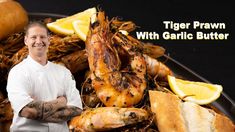 a man standing in front of a plate of food with tiger prawn and garlic butter