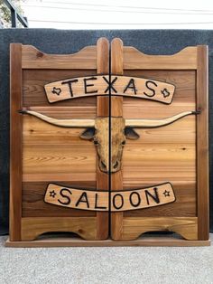 the texas saloon sign is made out of wood and has long horns on each side