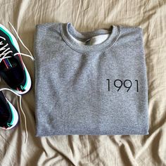 a pair of sneakers and a t - shirt with the number nineteen on it sitting on top of a bed