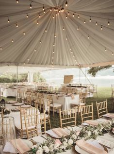 an outdoor tent with tables and chairs set up for a wedding reception under a canopy