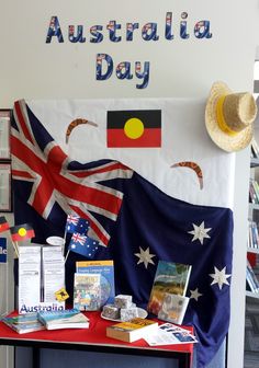 there is a flag and other items on the table in front of this sign that says australia day