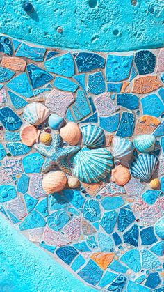 colorful sea shells and seashells on a mosaic tile wall in the shape of a heart