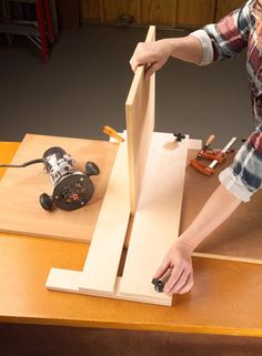 a man working on woodworking with a router and drill bit in the middle