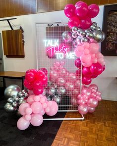 pink and silver balloons in front of a sign that says talk to me